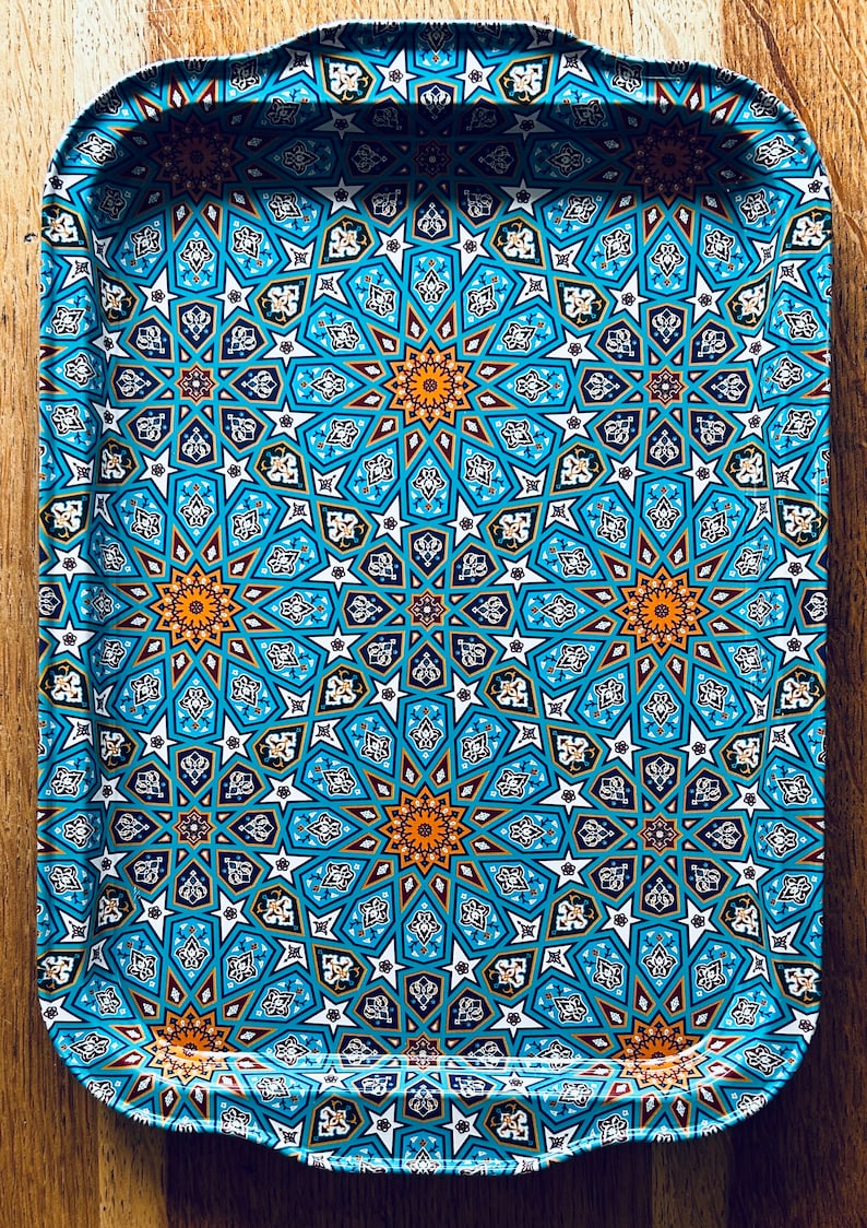 May include: A blue and gold tray with a geometric pattern. The tray has a rounded edge and is made of metal.