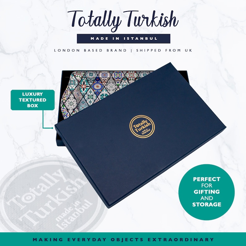 May include: A blue box with a lid open, revealing a decorative ceramic tray with a colorful geometric pattern. The box has the text "Totally Turkish" and "Made in Istanbul" on it. The tray is perfect for serving or storing items.