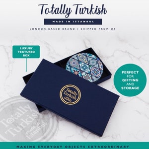 May include: A round, blue and white ceramic coaster with a geometric pattern. The coaster is in a blue box with the words "Totally Turkish" and "Made in Istanbul".