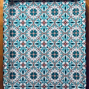 May include: A white serving tray with a blue and red geometric pattern. The tray has a scalloped edge.