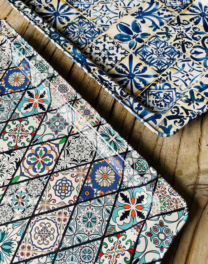 May include: Two rectangular trays with a colorful geometric pattern. The trays are made of metal and have a glossy finish. The pattern is reminiscent of traditional tile designs.