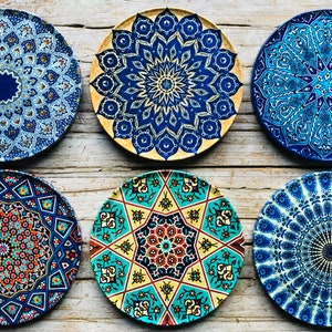 May include: Six decorative ceramic plates with intricate blue, yellow, and red geometric patterns. The plates feature a variety of mandala designs.