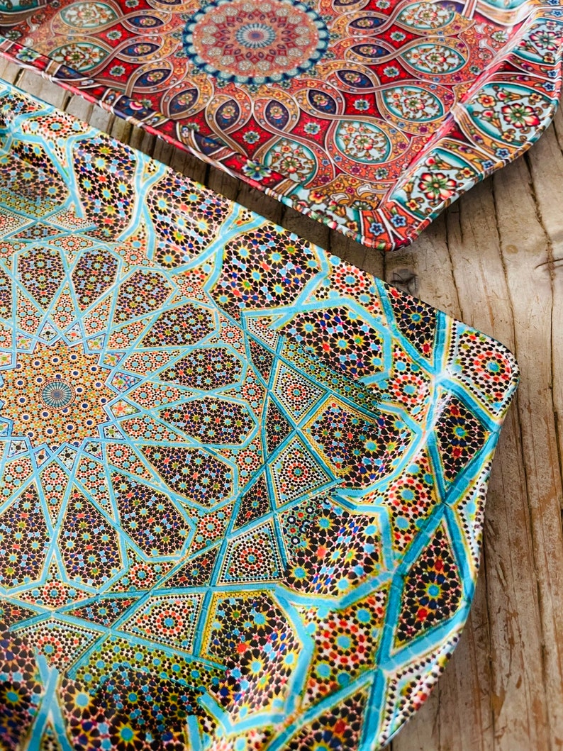 May include: Two decorative trays with intricate geometric patterns. The top tray is red, blue, and gold with a circular design. The bottom tray is blue, green, and gold with a starburst design.