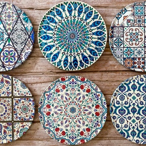 May include: Six round ceramic plates with intricate blue, green, and white geometric patterns. The plates have a white background and feature various floral and geometric designs.