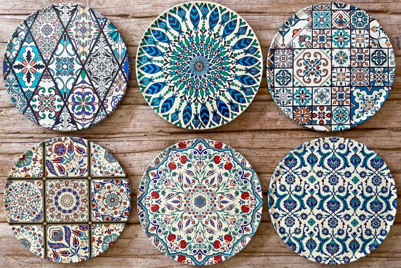 May include: Six round ceramic plates with intricate blue, green, and white geometric patterns. The plates have a white background and feature various floral and geometric designs.