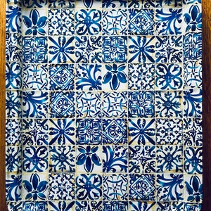 May include: A blue and white ceramic tray with a decorative tile pattern. The tray has a scalloped edge and is perfect for serving snacks or drinks.