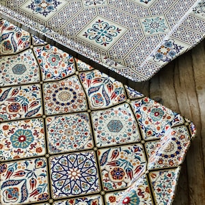May include: Two decorative trays with a white background and intricate blue, red, and gold patterned designs inspired by traditional Turkish tiles.