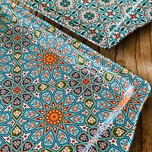 May include: Two decorative trays with a blue and white geometric pattern. The trays are made of metal and have a slightly raised edge.