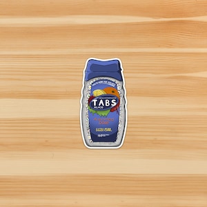 May include: A sticker featuring a blue and white container labeled "TABS ALLACID." The container has a blue cap and displays images of fruit. Text includes "Assorted Dose" and "Extra 1500 Strength."