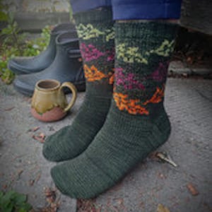 May include: A pair of green socks with a colorful, geometric pattern. The socks are made of a soft, comfortable material and are perfect for everyday wear.