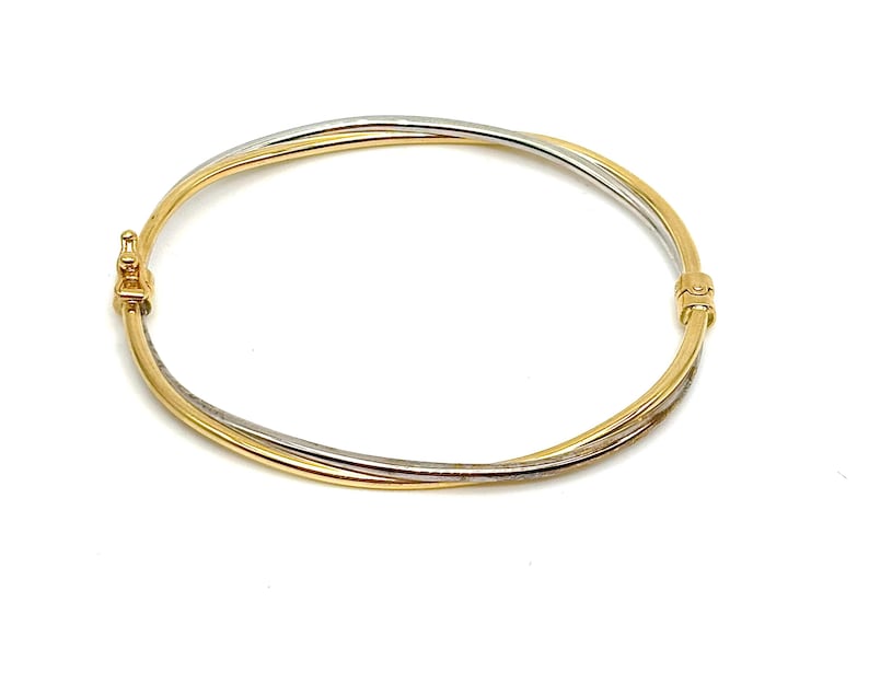Pode incluir: Um bracelete de ouro e prata com um design tran&ccedil;ado.