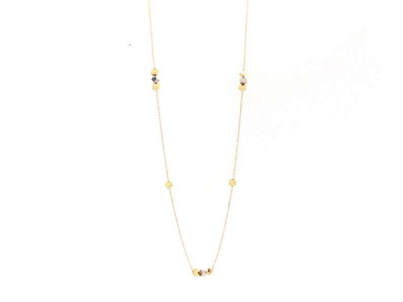 Op de afbeelding: Een gouden ketting met kleine ronde gouden bedels.