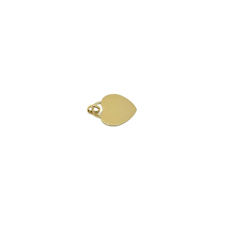 K&ouml;nnte beinhalten: Ein goldener herzf&ouml;rmiger Anh&auml;nger mit einer &Ouml;se oben zum Anbringen an einer Kette.