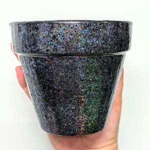 May include: A black terracotta planter pot with iridescent glitter embedded in the surface.