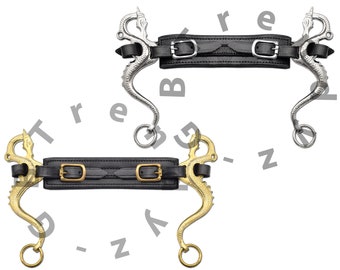 May include: Two silver and gold dragon bit horse bridles with black leather straps. The bridles have a dragon design on the mouthpiece and are attached to a black leather strap with two buckles.