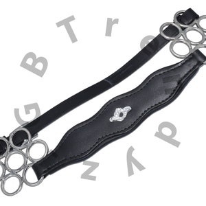 Op de afbeelding: Zwart lederen bitband met een zilveren ringbit. Het band heeft een decoratief zilveren ontwerp in het midden.