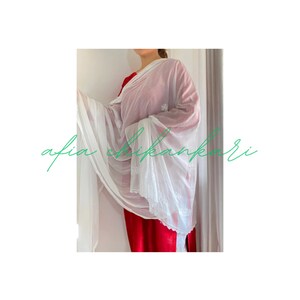 May include: A white sheer dupatta with delicate white embroidery. The dupatta is draped over a person wearing a red dress. The text "afia chikankari" is visible in the lower left corner of the image.