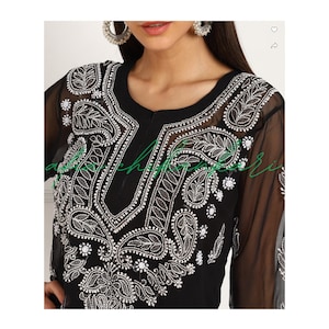 May include: Black sheer tunic with silver embroidery and embellishments. The embroidery features paisley and floral patterns.