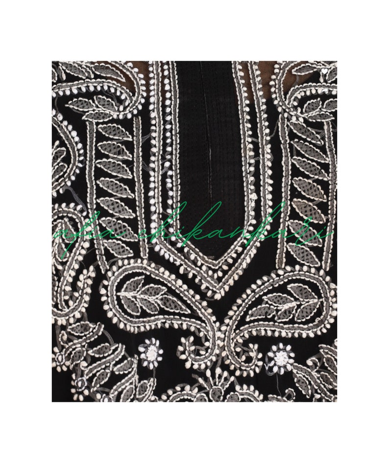 May include: Black fabric with white embroidery featuring paisley and floral patterns. The embroidery is detailed and intricate.