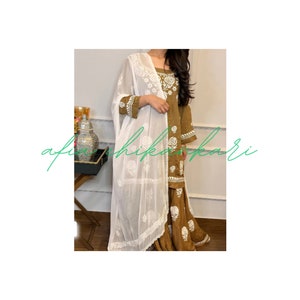 May include: A brown and white embroidered dress with a white dupatta. The dress has a floral pattern and the dupatta is sheer.