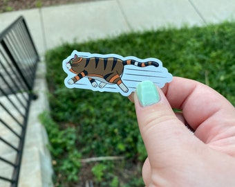 May include: A sticker of a cartoon cat running with a blur effect behind it. The cat is brown, orange, and white with pink ears.