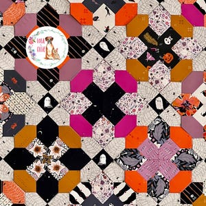 May include: A patchwork quilt featuring a repeating geometric pattern of octagons and diamonds in black, orange, purple, and white. The fabric displays Halloween-themed prints including ghosts, spiders, webs, skulls, and pumpkins. A circular logo reads Lola & Ellie.