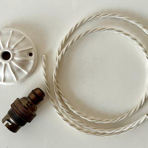Può includere: Una rosetta per soffitto in ceramica bianca, una presa per lampadina in ottone e un cavo elettrico intrecciato bianco.