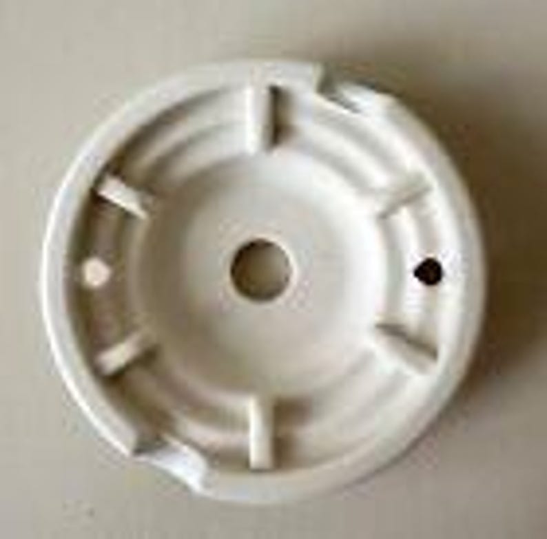 May include: White ceramic ceiling fixture with a central hole and five slots around the edge.