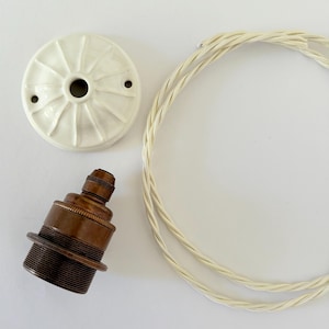 Luminária de teto tradicional com plafon estampado, soquete E27 em latão envelhecido e cabo de tecido trançado.