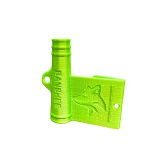 May include: A bright green bottle opener with a fox logo and the word "BANSHEE" printed on the side. The opener has a handle and a rectangular section with a fox head design and a hole.