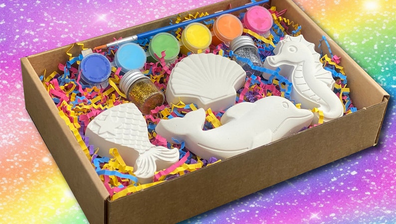 Pu&ograve; includere: Un kit per lavoretti con una variet&agrave; di figurine in ceramica a tema marino, tra cui una coda di sirena, una conchiglia, un delfino e un cavalluccio marino. Il kit include anche sei piccoli barattoli di vernice, un pennello e un piccolo barattolo di glitter.