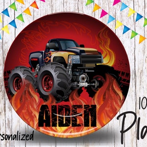 May include: Personalized 10-inch red plate with a black and yellow monster truck with flames. The truck has large tires and the name "Aiden" is printed on the plate.