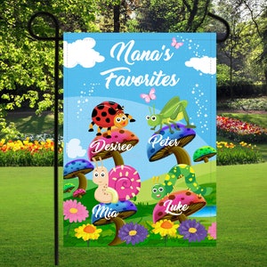 May include: A colorful garden flag with the text "Nana's Favorites" and four mushroom-shaped designs with the names "Desiree", "Peter", "Mia", and "Luke" on them. Each mushroom has a different bug or insect on top.
