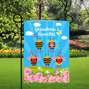May include: A blue and white garden flag with a bee theme. The flag says "Grandma's Favorites" with a bee for each grandchild. The bees have names: Conner, Jessica, Ariana, Sammy, and Mia.