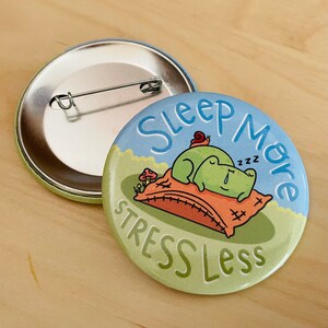 May include: A green frog with a red snail on its back is sleeping on a pillow with the text "Sleep More Stress Less" on a blue and green background. The image is a button.