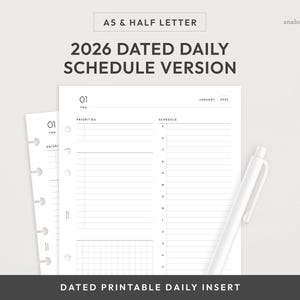 May include: A5 & Half Letter 2026 dated daily schedule version printable insert. The white insert features a daily schedule layout with sections for priorities and a schedule. A white pen rests on the right side of the insert.