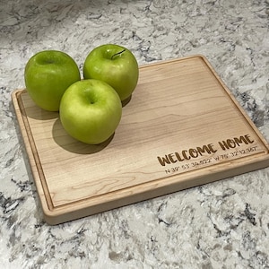 May include: A rustic wooden sign with the text "Welcome to our home" in white lettering. The sign features a distressed finish and a simple, inviting design, perfect for front door decor.