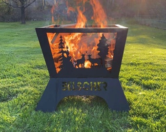 May include: A black metal fire pit with a deer and tree design. The fire pit is burning with flames and has the name "GELSCHER" on the front.