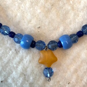 22-10. SALE! This sweet 17&quot; necklace has a yellow glass star hanging from a string of blue beads. Was 15 dollars, now 10.