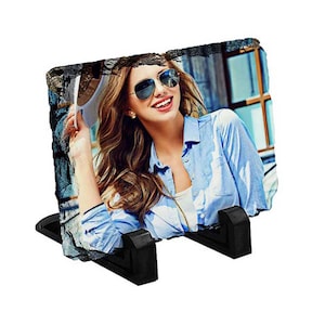 May include: A photo slate with a black stand, featuring a photo of a woman wearing sunglasses and a hat. The photo is printed on a natural slate stone.