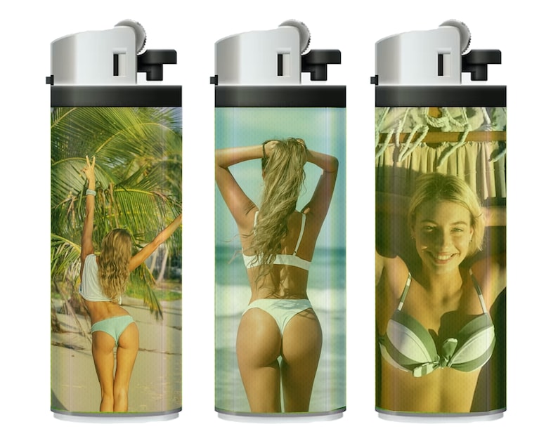 May include: Three silver lighters with different images printed on them. The first lighter has a woman in a bikini standing on a beach with palm trees in the background. The second lighter has a woman in a bikini standing on a beach with her back to the camera. The third lighter has a woman in a bikini smiling at the camera.