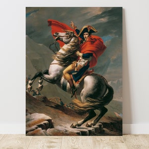 May include: A painting of Napoleon Bonaparte on horseback, wearing a red cloak and a bicorne hat. He is riding a white horse with a flowing mane and tail. The background is a mountainous landscape with a stormy sky.