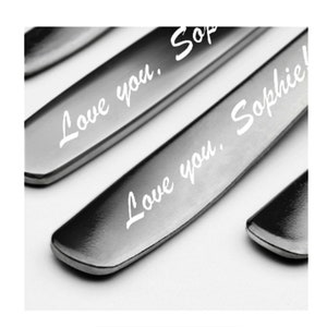 May include: Close-up of a silver knife with the words "Love you, Sophie!" engraved on the blade.