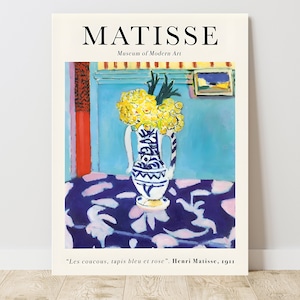 May include: A painting by Henri Matisse titled "Les coucous, tapis bleu et rose" depicting a vase of yellow flowers on a blue and pink patterned tablecloth. The painting is from 1911.