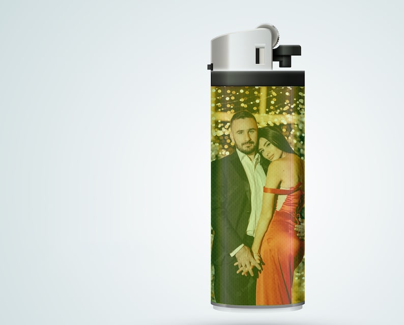 May include: A black and silver lighter with a personalized photo of a couple in a festive setting. The photo shows a man and a woman in a romantic pose, with a blurred background of lights.