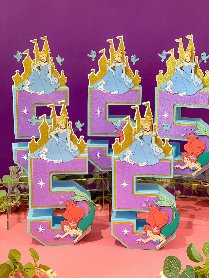 May include: A set of five purple and blue foam numbers decorated with Disney princesses. The numbers are 1, 5, and 5. Cinderella is featured on the 1s and the 5s feature Ariel the mermaid.
