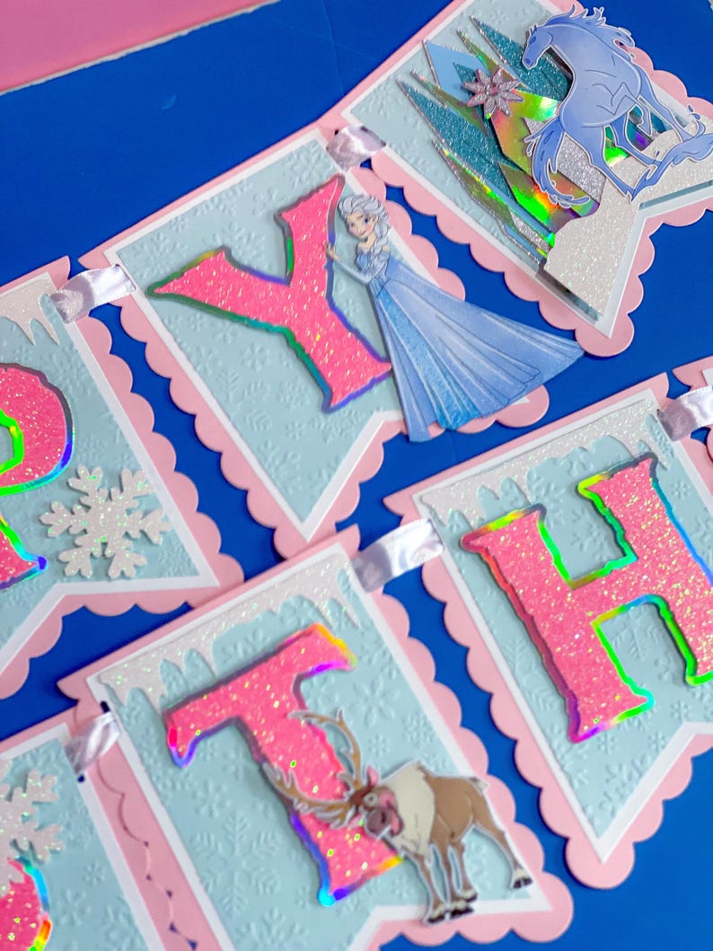 Może przedstawiać: Dekoracyjny baner z r&oacute;żowymi, brokatowymi literami, kt&oacute;re układają się w napis "HAPPY BIRTHDAY". Litery umieszczone są na jasnoniebieskich banerach z r&oacute;żowymi, falistymi obramowaniami. Projekt zawiera wizerunki księżniczki, konia i renifera.