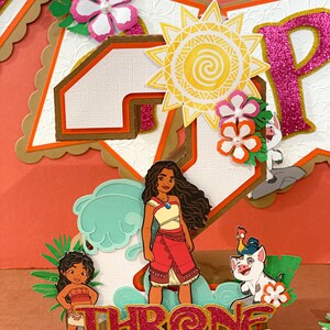 May include: A colorful birthday banner with a tropical theme. The banner features the word "THRONE" in glittery red letters, along with cutouts of Moana and other characters. The background includes a large number "4" and decorative flowers.