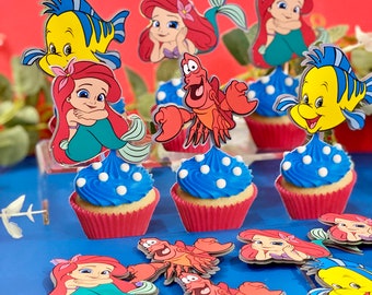 May include: A set of cupcake toppers featuring characters from The Little Mermaid. The toppers include Ariel, Flounder, Sebastian, and a few other characters. The toppers are printed on cardstock and are perfect for adding a touch of Disney magic to your cupcakes.