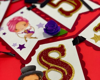 May include: A white banner with red scalloped edges and a gold glitter number 8. The banner also features a cartoon illustration of a ringmaster wearing a red and gold costume and a top hat. The banner is decorated with purple and white stars.